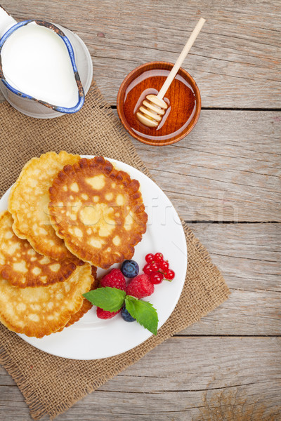 Pancakes with raspberry, blueberry, milk and honey syrup Stock photo © karandaev