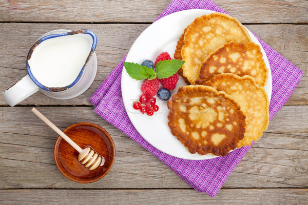 Pancakes with raspberry, blueberry, milk and honey syrup Stock photo © karandaev