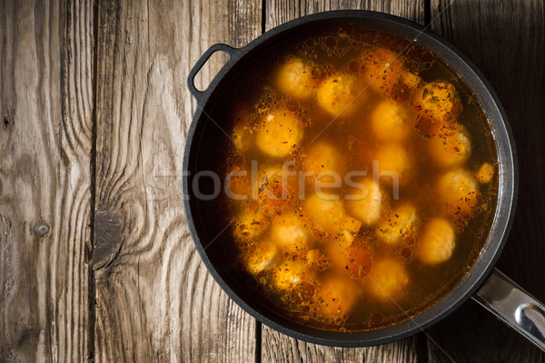 Cooked meatballs in a stewpot on the old boards on right Stock photo © Karpenkovdenis