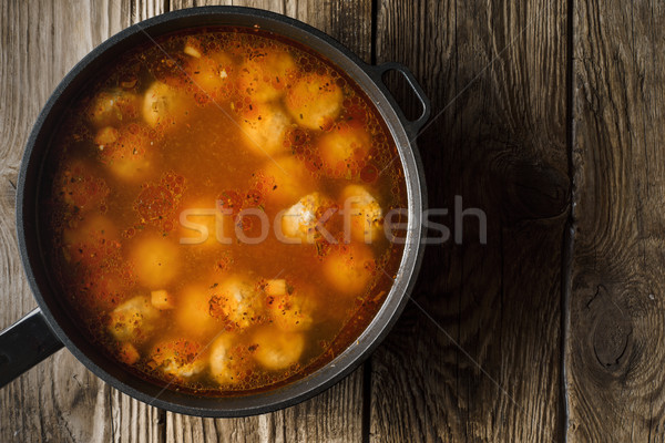Cooked meatballs in a stewpot on the old boards on left Stock photo © Karpenkovdenis
