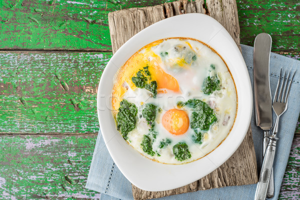Florentine eggs with pureed spinach on the wooden table top view Stock photo © Karpenkovdenis