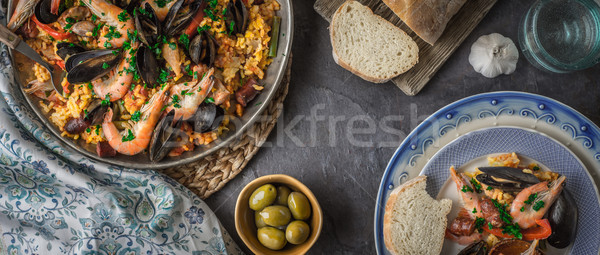 Plates with paella on the dark stone table with different accessories wide screen Stock photo © Karpenkovdenis