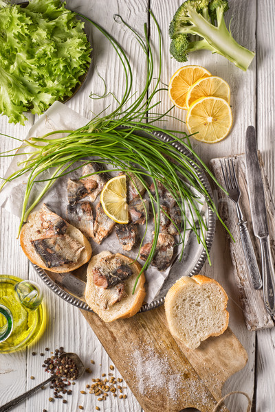 Fresh greens, sardines, bread on a wooden table Stock photo © Karpenkovdenis