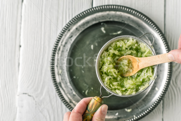 Grated cucumbers in the strainer with wooden spoon top view Stock photo © Karpenkovdenis