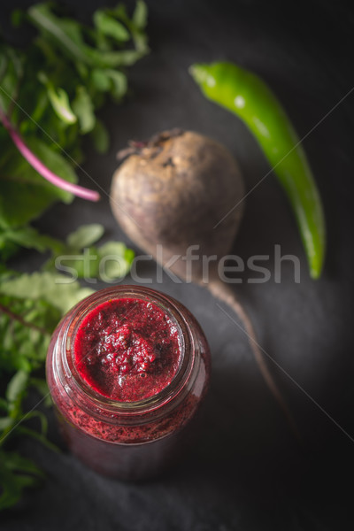 Stock photo: Vegetable smoothie with blurred ingredients on the dark stone background vertical