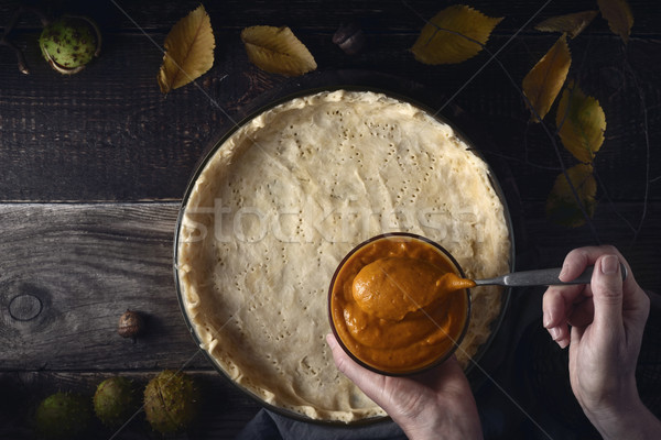 Putting  pumpkin puree on the dough for pumpkin pie top view Stock photo © Karpenkovdenis