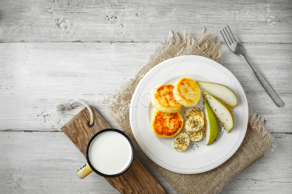 Cheesecakes with pear and milk on a white plate Stock photo © Karpenkovdenis