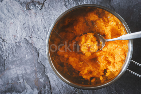 Pumpkin puree in the pot with spoon in the stone background top view Stock photo © Karpenkovdenis