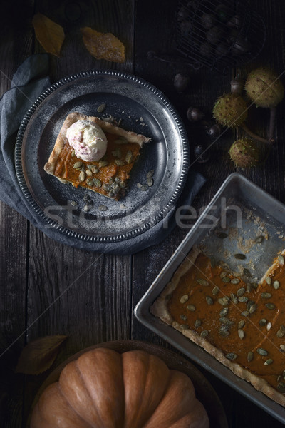 Slice of pumpkin pie with ice cream on the metal plate on the wooden table top view Stock photo © Karpenkovdenis