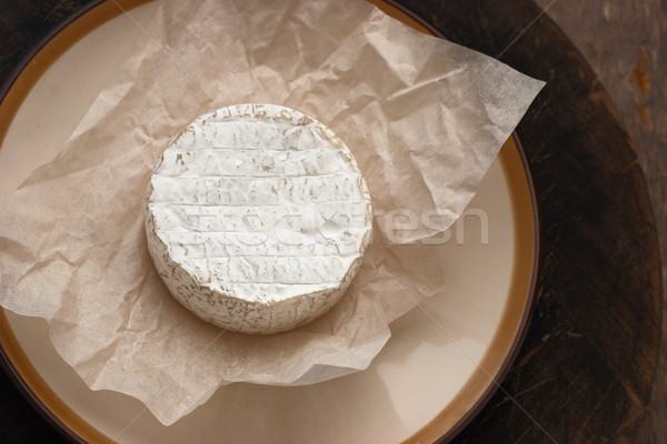 Whole camembert cheese on the white parchment Stock photo © Karpenkovdenis