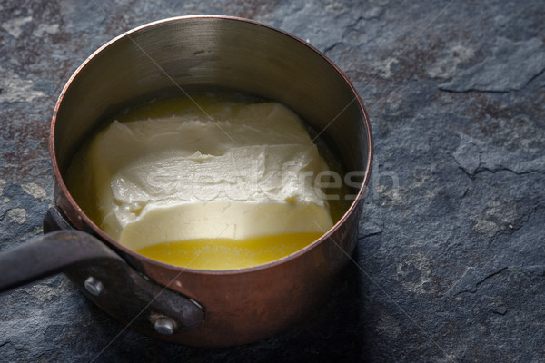 Melted butter in the stewpan on the stone background horizontal Stock photo © Karpenkovdenis