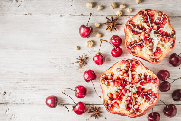 Still life with pomegranate , cherry and spices on the white wooden table. Concept of oriental fruit Stock photo © Karpenkovdenis