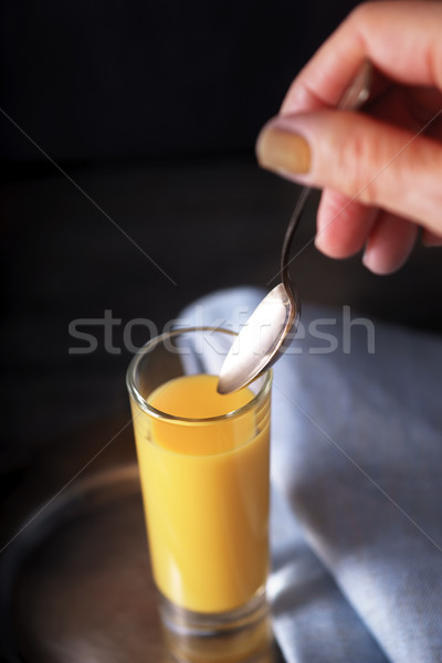 Stock photo: Egg liqueur  in the glass with spoon in the hand