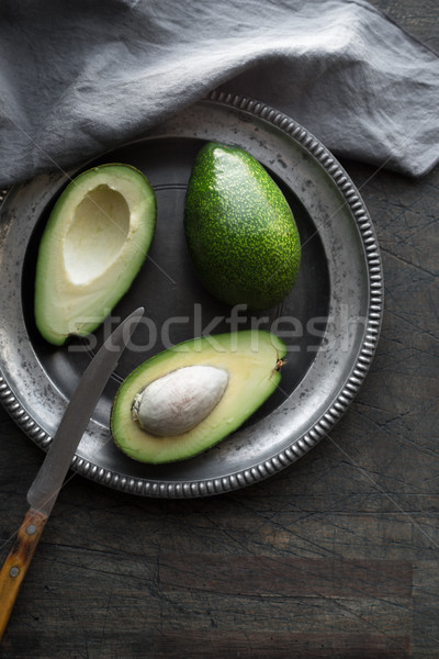 Avocado in the metal plate on the dark scratched table Stock photo © Karpenkovdenis
