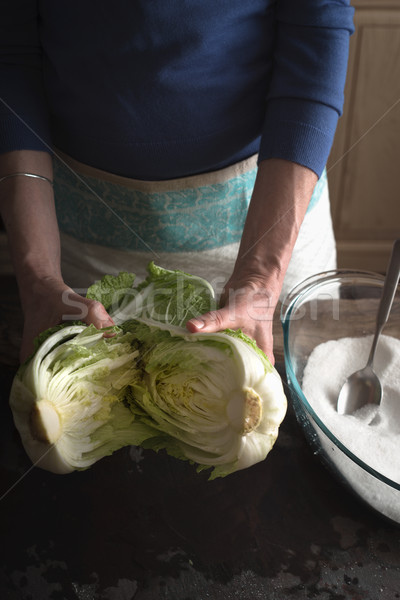 Woman Chinese cabbage divided into two halves for making kimchi Stock photo © Karpenkovdenis