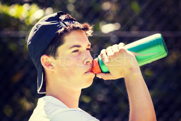 Hombre agua potable joven beber botella adolescente Foto stock © keeweeboy