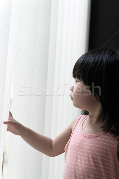 Sad little girl looking at window Stock photo © kenishirotie