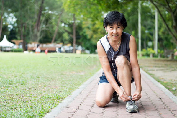 Senior jogger tighten her running shoe laces Stock photo © kenishirotie