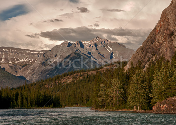 Dark clouds are moving in during sunset on the river near Banff  Stock photo © Klodien