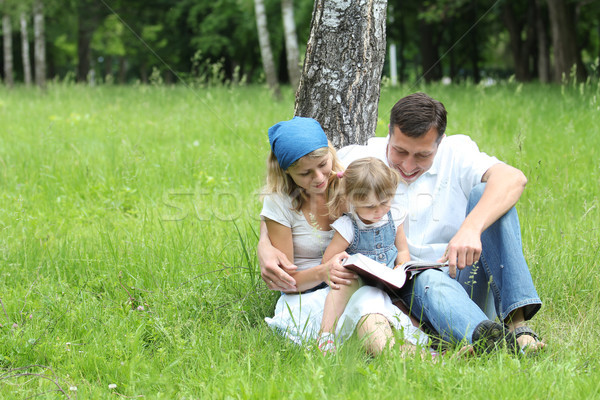 Tineri familie lectură Biblie natură copii Imagine de stoc © koca777