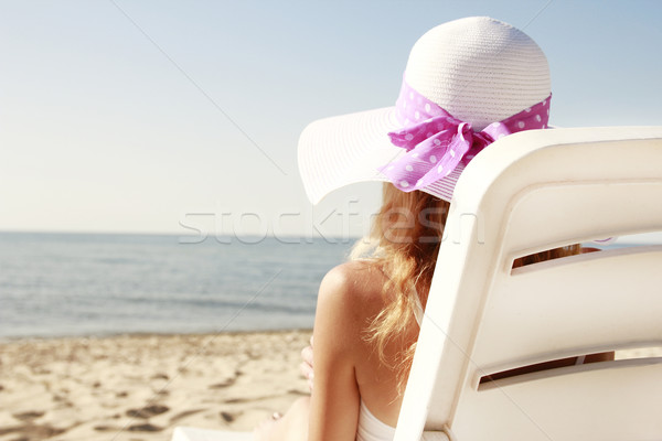 girl in hat is lying on a deck chair on the beach Stock photo © koca777