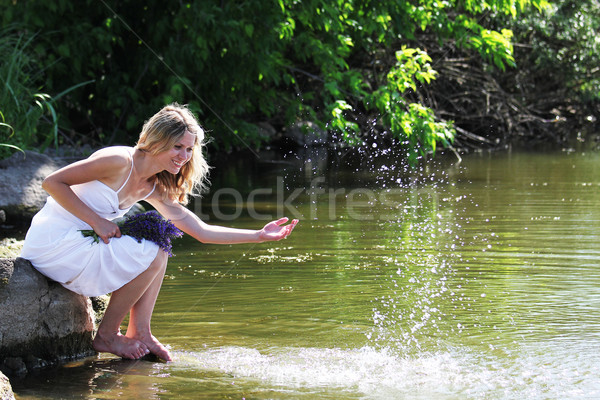 young woman sprinkles water near the lake Stock photo © koca777