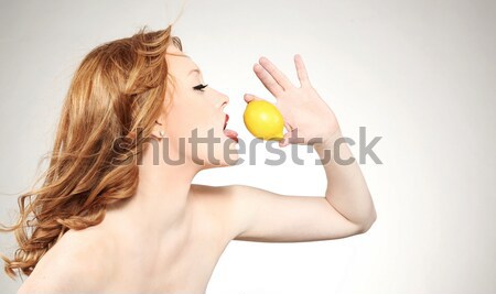 Stock photo: Young woman holding a lemon