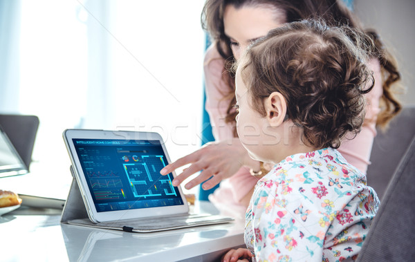 Woman teaching her daughter tablet handling Stock photo © konradbak