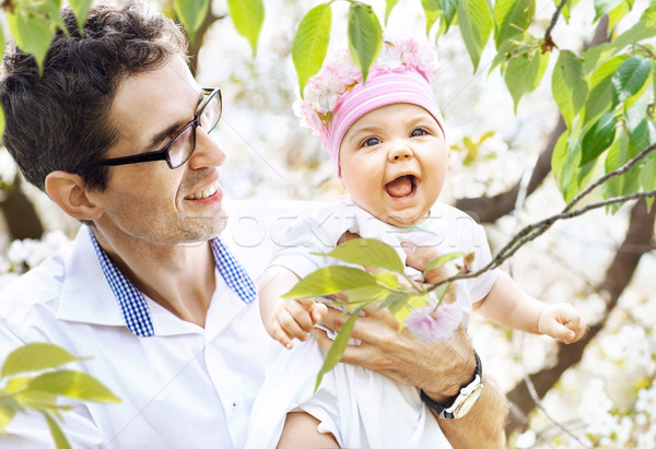 Handsome father looking at his lauhging baby Stock photo © konradbak