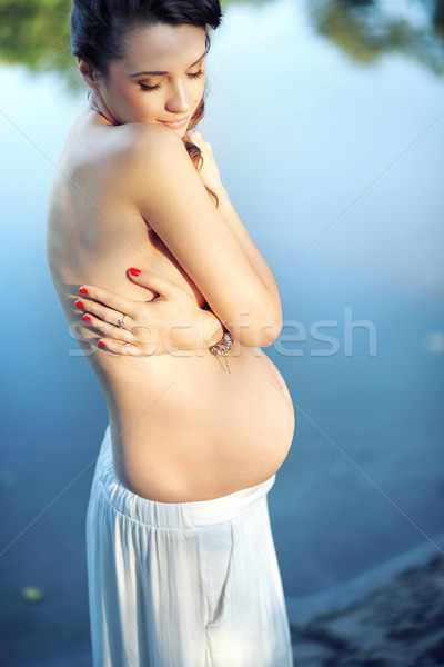 Half naked pregnant woman by the lakeside Stock photo © konradbak