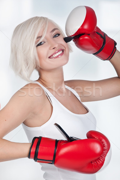 Cheerful blond woman doing make up in boxing gloves Stock photo © konradbak