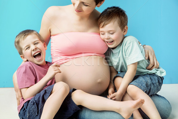 Glad pregnant mom embracing her cute sons Stock photo © konradbak