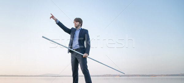 Handsome manager holding long stick Stock photo © konradbak