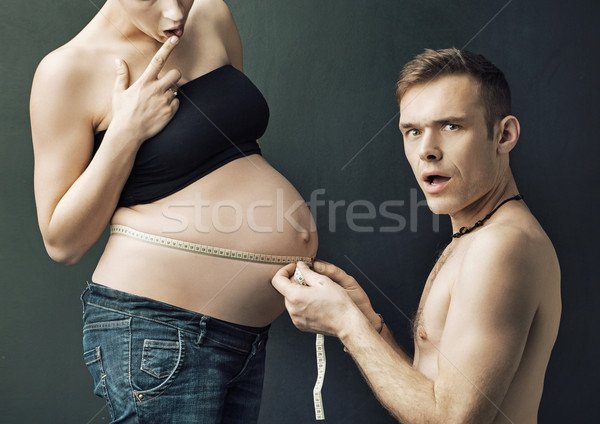 Happy parents measuring on pregnant woman's belly Stock photo © konradbak
