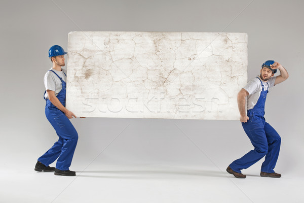 Two workers carrying crashed banner Stock photo © konradbak