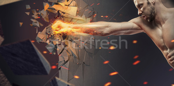 Muscular athlete crushing the wall Stock photo © konradbak