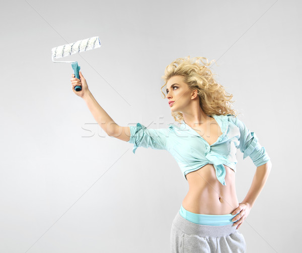 Alluring young woman holding the paint roller Stock photo © konradbak