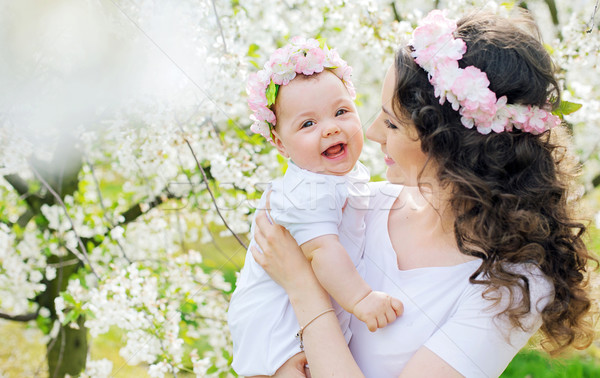 Young mother and her little baby relaxing in a spring orchard Stock photo © konradbak