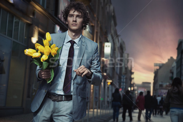 Eleganten Mann halten Blumen Fuß Lächeln Stock foto © konradbak