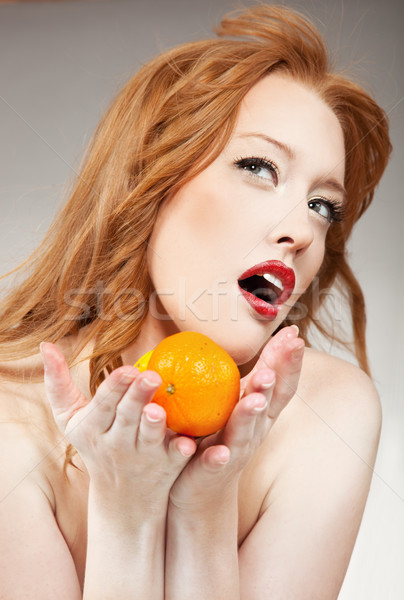 Young woman holding an orange Stock photo © konradbak