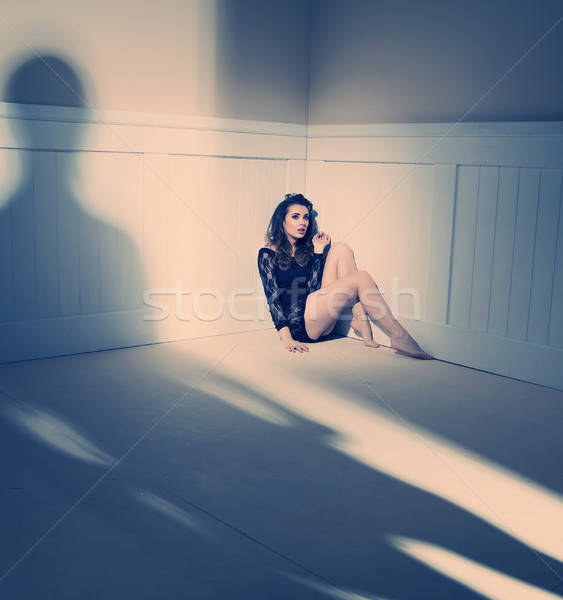 Sad woman sitting alone in a empty room Stock photo © konradbak