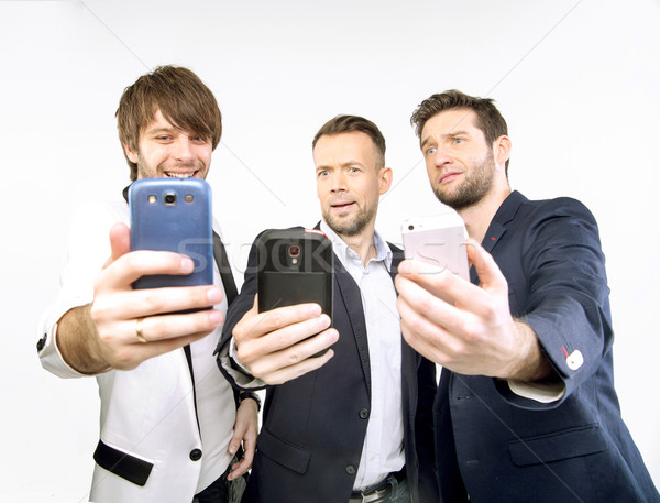 A few guys uisng their smart phones Stock photo © konradbak