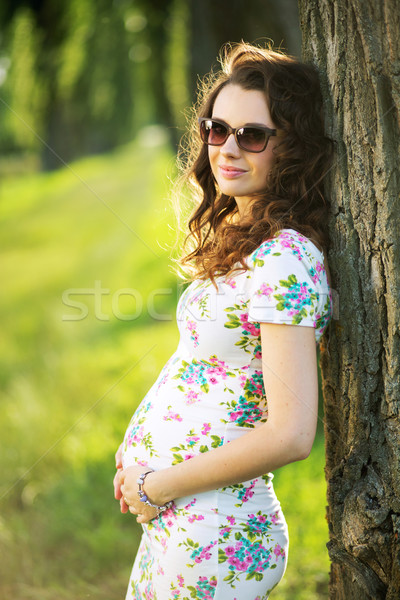 Stock photo: Marvelous pregnant woman leaning against the tree