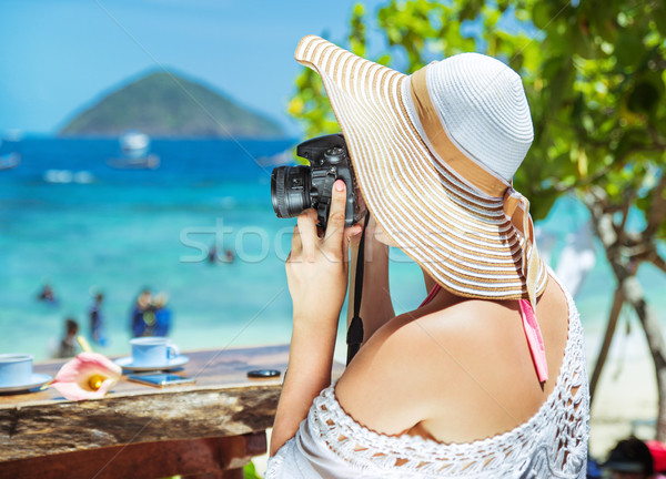 Relaxed, joyful lady taking a photo of a tropical beach Stock photo © konradbak