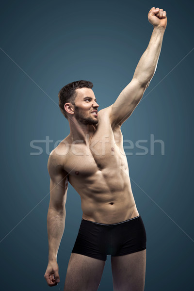 Handsome man making the muscles Stock photo © konradbak