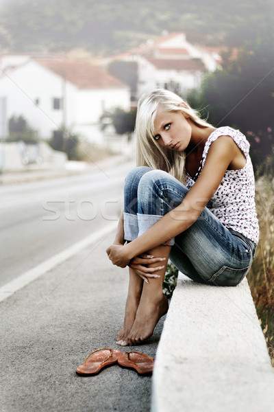 Young blonde sitting by the road Stock photo © konradbak