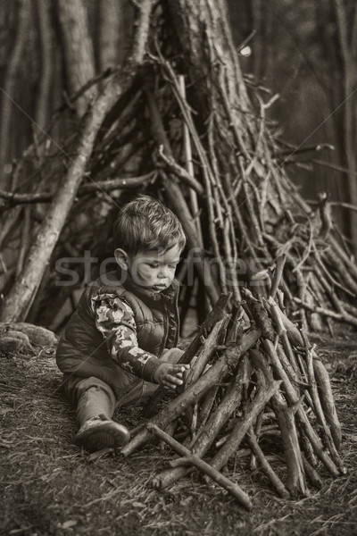 Cute little boy building a wooden hut Stock photo © konradbak