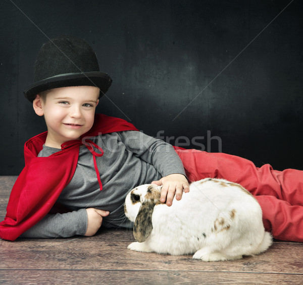 Little magician boy stroking a bunny Stock photo © konradbak