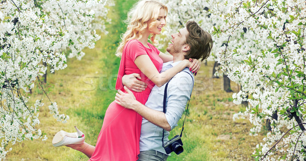 Joyful couple in the fragrant orchard Stock photo © konradbak