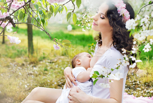 Mother feeding a baby in the orchard Stock photo © konradbak